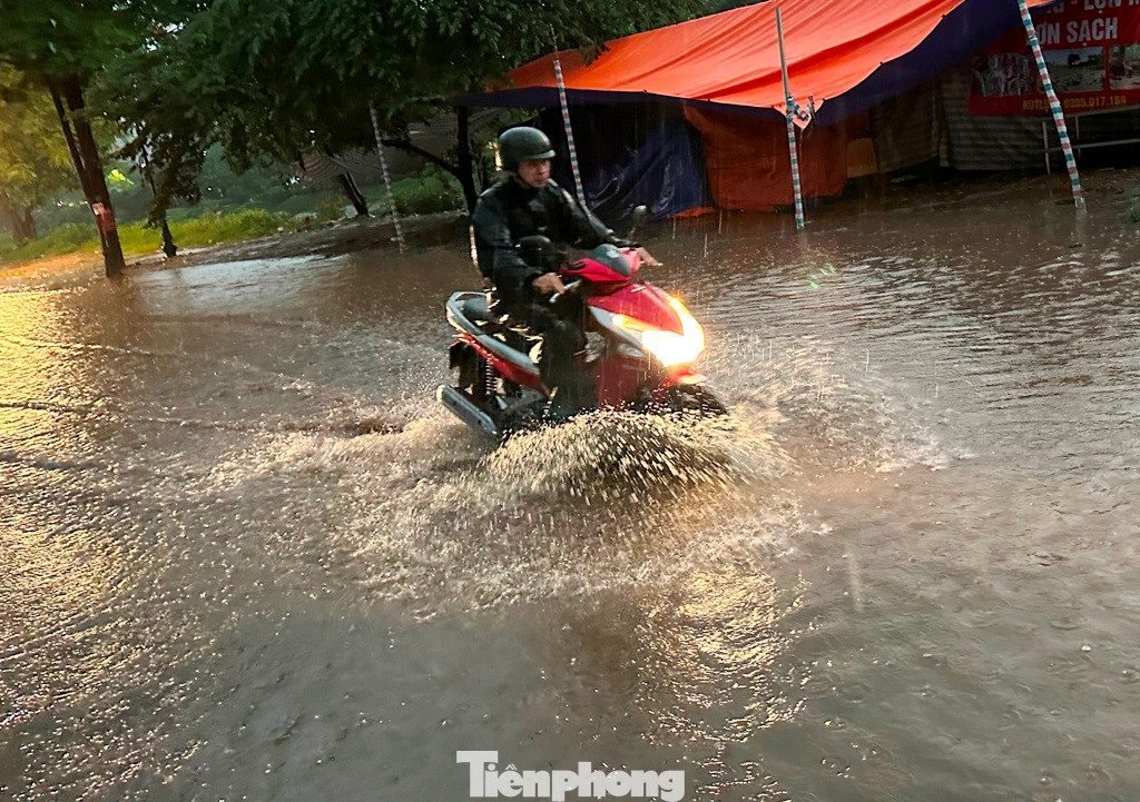 Mưa rào chỉ diễn ra khoảng 45 phút nhưng nhiều tuyến phố nước đã ngập hơn nửa bánh xe máy. Ảnh chụp trên phố Kim Giang chiều tối 19/5.