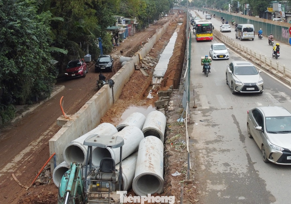 Phương tiện đang phải đi qua hàng rào công trường dựng ở hai bên để lưu thông trên đường Âu Cơ - Nghi Tàm.