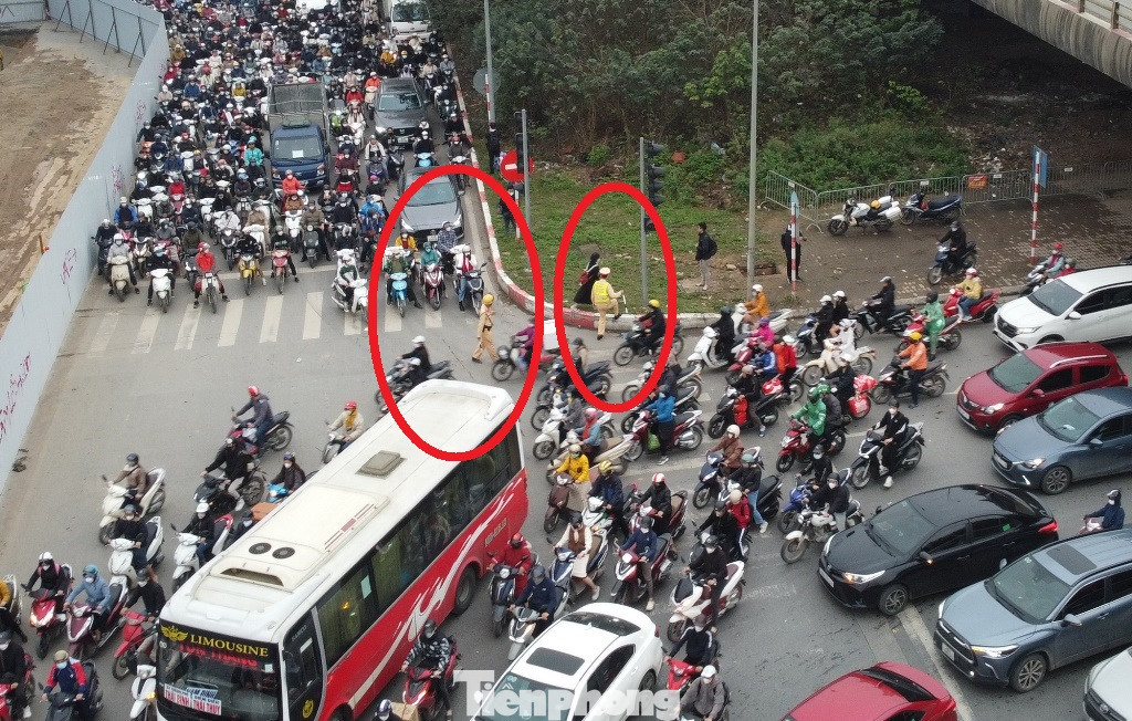 Khi ùn tắc xảy ra trên diện rộng, kéo dài từ các hướng, việc điều tiết không còn hiệu quả, tổ CSGT làm nhiệm vụ tại đây (vòng tròn đỏ) trong sáng 20/3 đã phải di chuyển lên vỉa hè, dải phân cách.