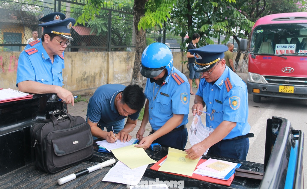 Lái xe khách (mặc áo phông) ký biên bản vi phạm lỗi dừng đỗ trên đường Giải Phóng ngày 24/5. Ảnh: Lê Hưng Lái xe khách (mặc áo phông) ký biên bản vi phạm lỗi dừng đỗ trên đường Giải Phóng ngày 24/5. Ảnh: Lê Hưng