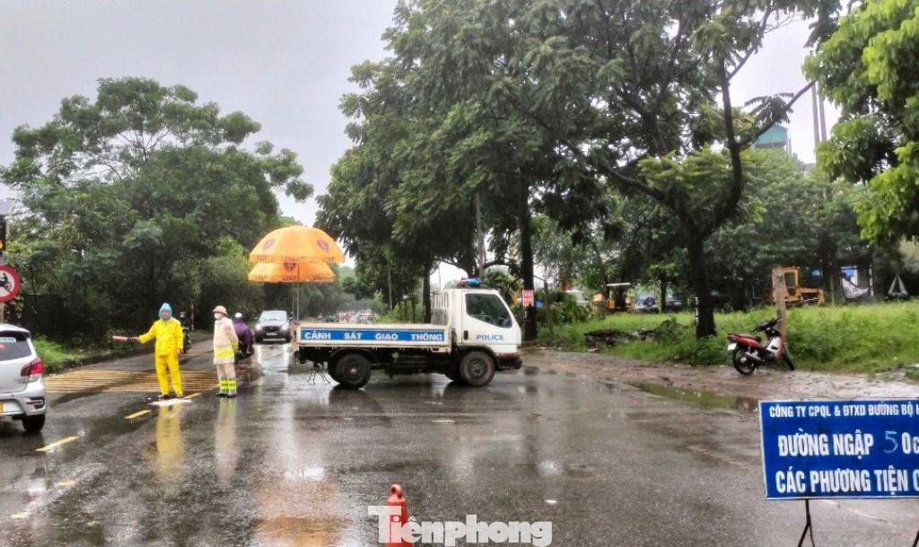 Trên phố Lê Trọng Tấn đi ra đường gom đại lộ Thăng Long theo hướng nội thành Hà Nội đang bị ngập nặng, CSGT đã phải dùng xe công vụ chặng ngang để cấm đường.