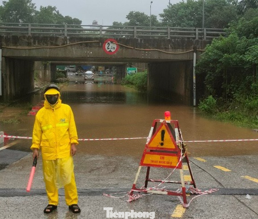 Các hầm chui đại lộ Thăng Long sáng nay vẫn ngập sâu, nhân viên Cty Thoát Nước Hà Nội đã phải căng rào, đứng điều tiết không cho xe đi qua để phòng tránh rủi ro.