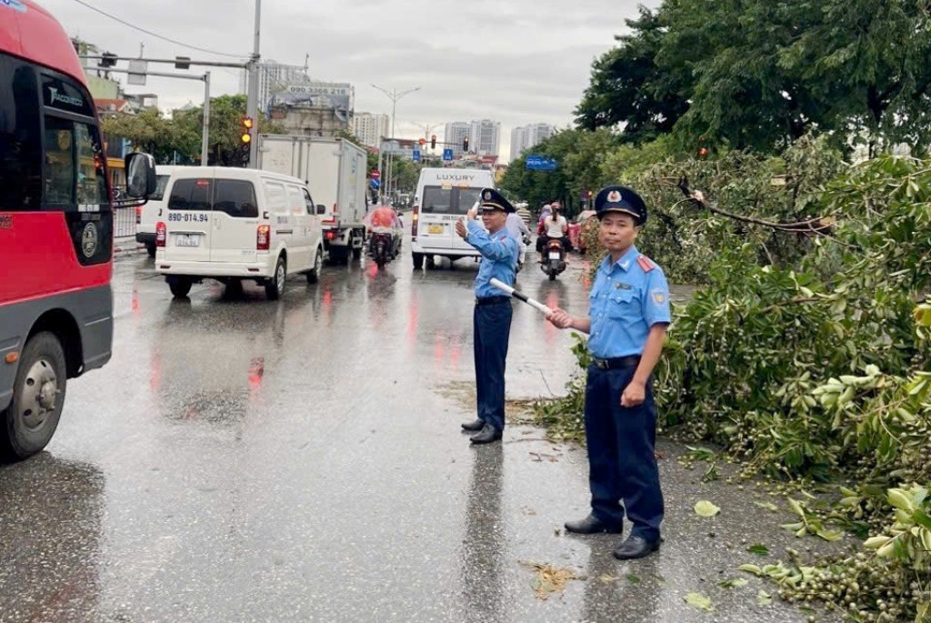 Tại các vị trí cây xanh đã được thu dọn hoặc gạt gọn vào lề đường, lực lượng chức năng đứng điều tiết đảm bảo giao thông.