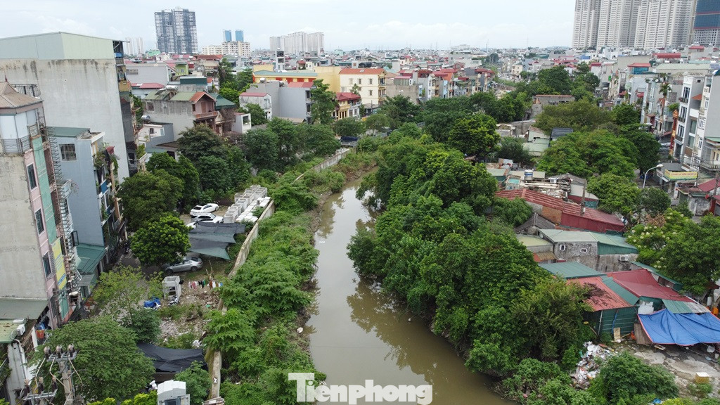 Có mặt tại đoạn kênh đang bị vướng mặt bằng ngày 31/7, PV Tiền Phong ghi nhận, mặt cắt chiều rộng của kênh dẫn là từ 24 - 40 mét, nhưng hiện lòng kênh dẫn qua quận Hà Đông nhiều đoạn chỉ như một đoạn mương nước thải, hai bên phạm vi dự án vẫn bị lấn chiếm nghiêm trọng.
