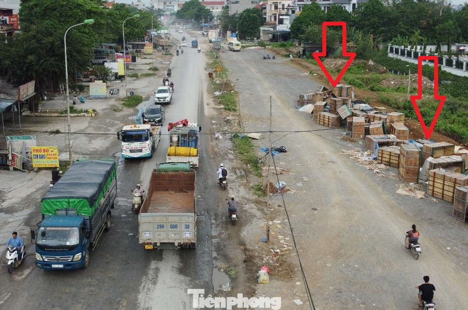 Thậm chí đoạn mặt bằng dự án đã được địa phương giải phóng còn rộng hơn cả đường chính, nhưng do chưa được thi công nên đang bị người dân lấn chiếm để làm nơi chứa đồ (mũi tên đỏ).