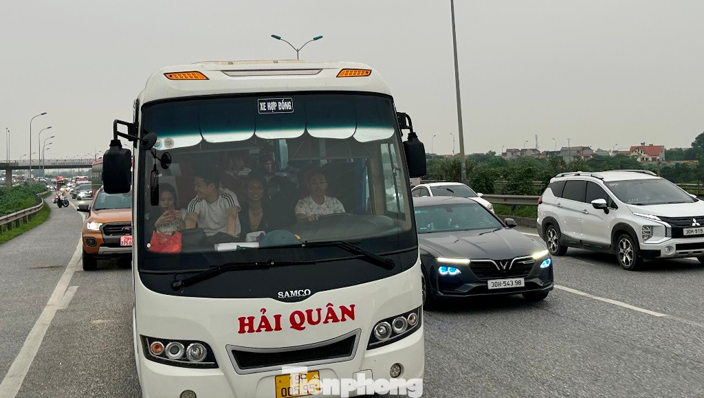 Xe khách chở chật ních người và nối dài cùng nhiều dòng xe cá nhân chậm chậm di chuyển trên cao tốc. Xe khách chở chật ních người và nối dài cùng nhiều dòng xe cá nhân chậm chậm di chuyển trên cao tốc.