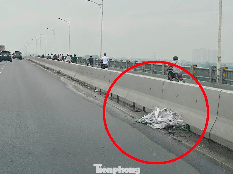 Bao tải và túi ni-lông được nước ngập cuộn tròn bịt kín miệng một hố ga thu nước.