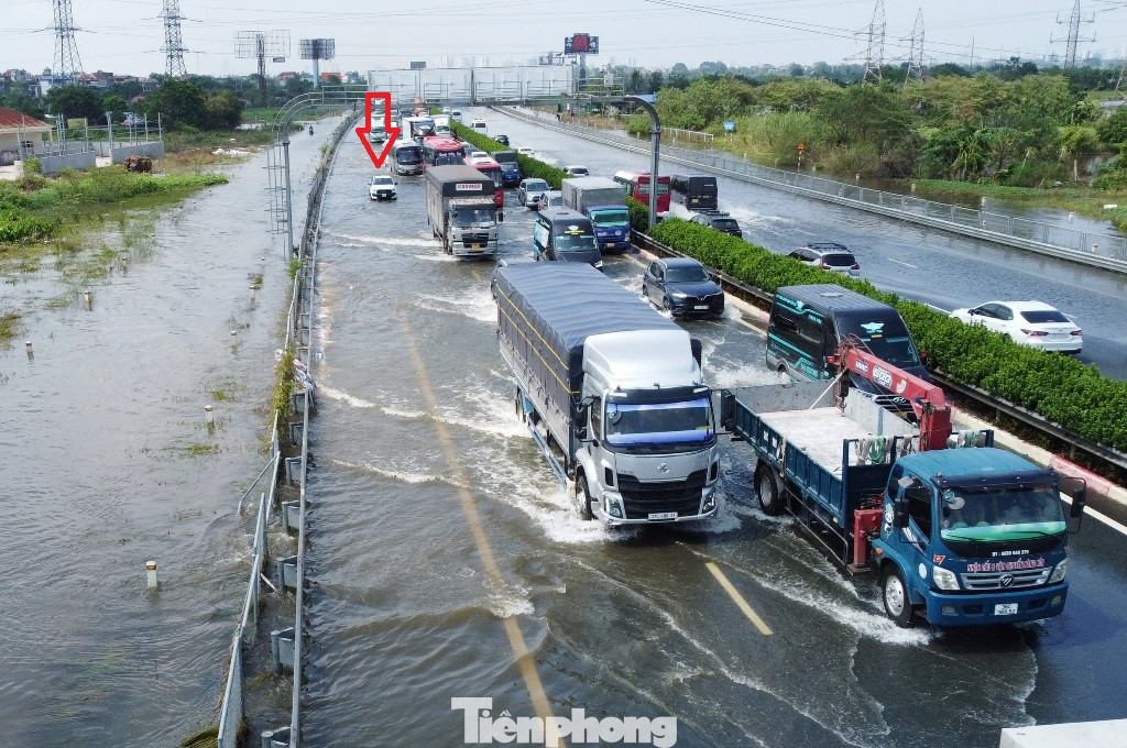 Mặc dù là xe gầm cao (SUV) nhưng do chiều 16/9 nước ngập trên cao tốc Pháp Vân - Cầu Giẽ vẫn ở mức nửa mét nên vẫn có một số xe bị chết máy, đứng yên tại chỗ (mũi tên đỏ). Mặc dù là xe gầm cao (SUV) nhưng do chiều 16/9 nước ngập trên cao tốc Pháp Vân - Cầu Giẽ vẫn ở mức nửa mét nên vẫn có một số xe bị chết máy, đứng yên tại chỗ (mũi tên đỏ).