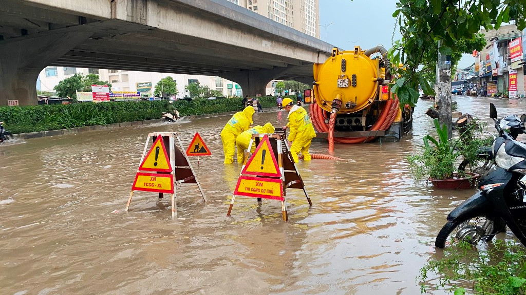 Tại các vị trí ngập sâu, cùng với huy động nhân viên đứng cảnh báo, Cty Thoát nước Hà Nội đã huy động cả xe thông hút đến để khai thông dòng chảy tại các hố ga thu nước.