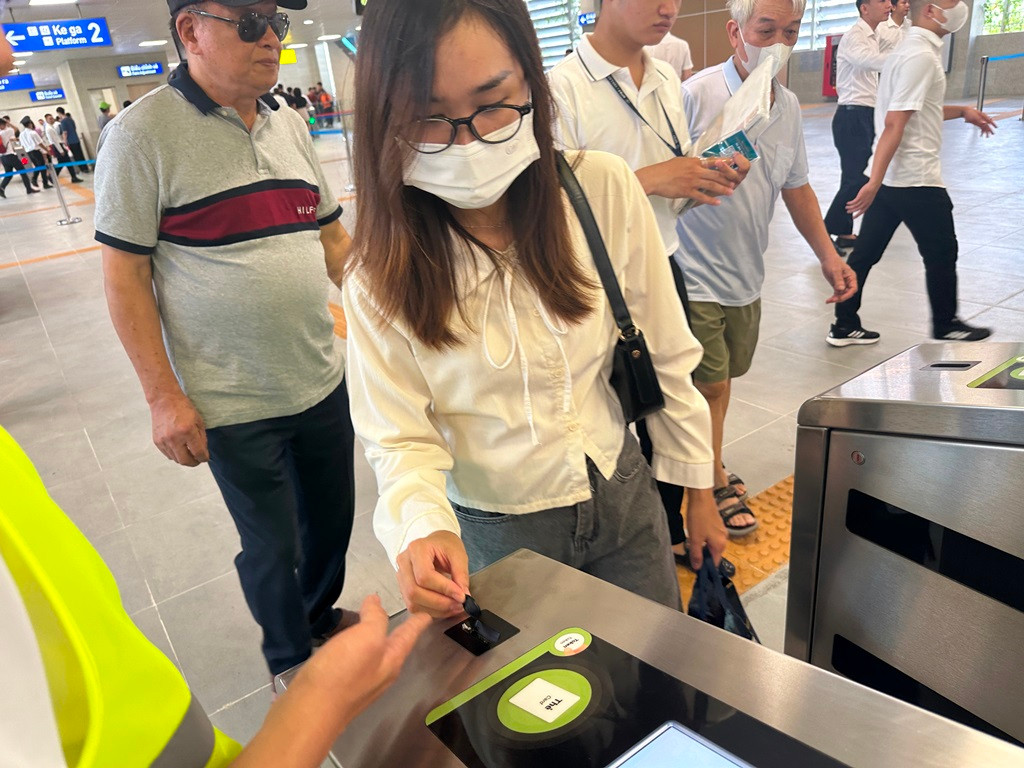 Người dân xếp hàng quẹt thẻ để vào trong khu vực sân đỗ của Ga vào 8h sáng nay.