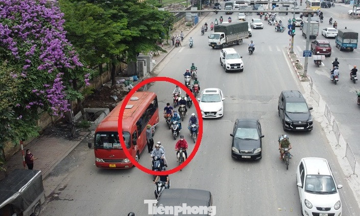 Ngoài vi phạm biển cấm, mỗi khi các xe khách dừng đỗ trên đường, sẽ có người từ trên xe hoặc từ xa chạy xe máy đến vô tư chèo kéo người đi đường lên xe (vòng tròn).