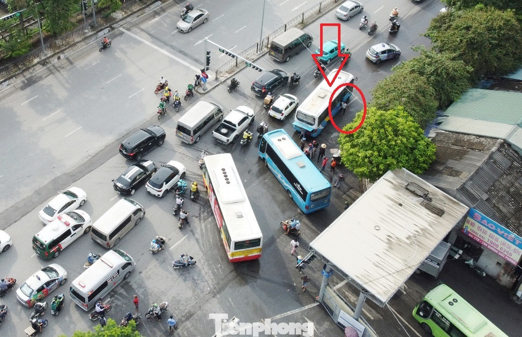 Thậm chí, việc đi lại khó khăn tại khu vực trước cổng bến Giáp Bát còn có nguyên nhân một số xe khách sau khi xuất bến còn dừng đỗ đón khách ngay trên đường. Trong ảnh: Xe khách BKS 18B-01071 nhà xe Tâm Lan (mũi tên), sau khi xuất bến Giáp Bát chiều 16/7 đã dừng ngay trước cổng để phụ xe xuống (vòng tròn đỏ) bắt thêm khách, mở cốp nhận hàng. Thậm chí, việc đi lại khó khăn tại khu vực trước cổng bến Giáp Bát còn có nguyên nhân một số xe khách sau khi xuất bến còn dừng đỗ đón khách ngay trên đường. Trong ảnh: Xe khách BKS 18B-01071 nhà xe Tâm Lan (mũi tên), sau khi xuất bến Giáp Bát chiều 16/7 đã dừng ngay trước cổng để phụ xe xuống (vòng tròn đỏ) bắt thêm khách, mở cốp nhận hàng.