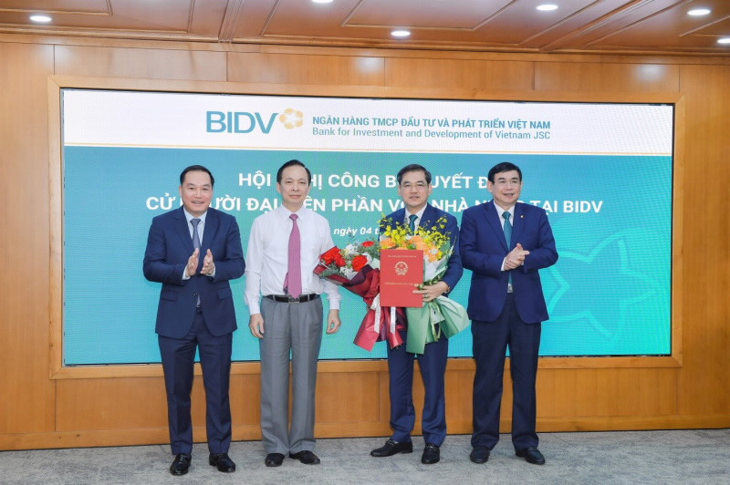 Phó Thống đốc thường trực NHNN Đào Minh Tú, Phó Bí thư Đảng ủy khối DNTW Hồ Xuân Trường trao Quyết định và chúc mừng ông Đặng Văn Tuyên (ảnh: SBV).