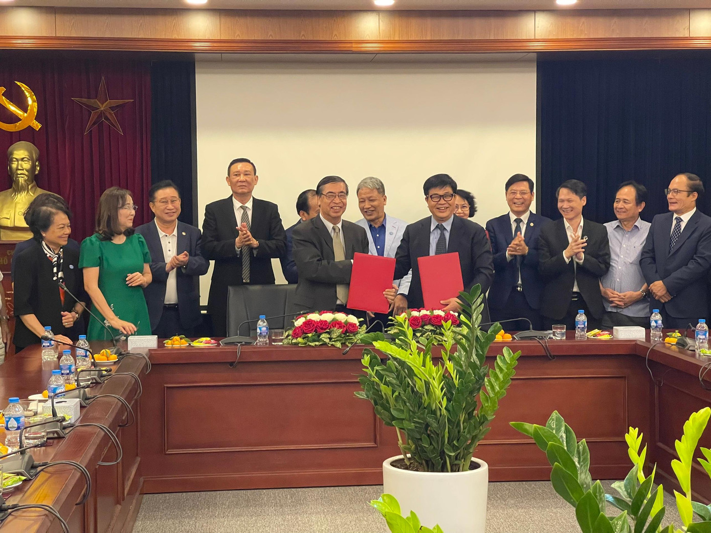 Ông Nguyễn Phú Bình và Đỗ Ngọc Thịnh trao đổi văn bản ký kết hợp tác. (Ảnh L.A)