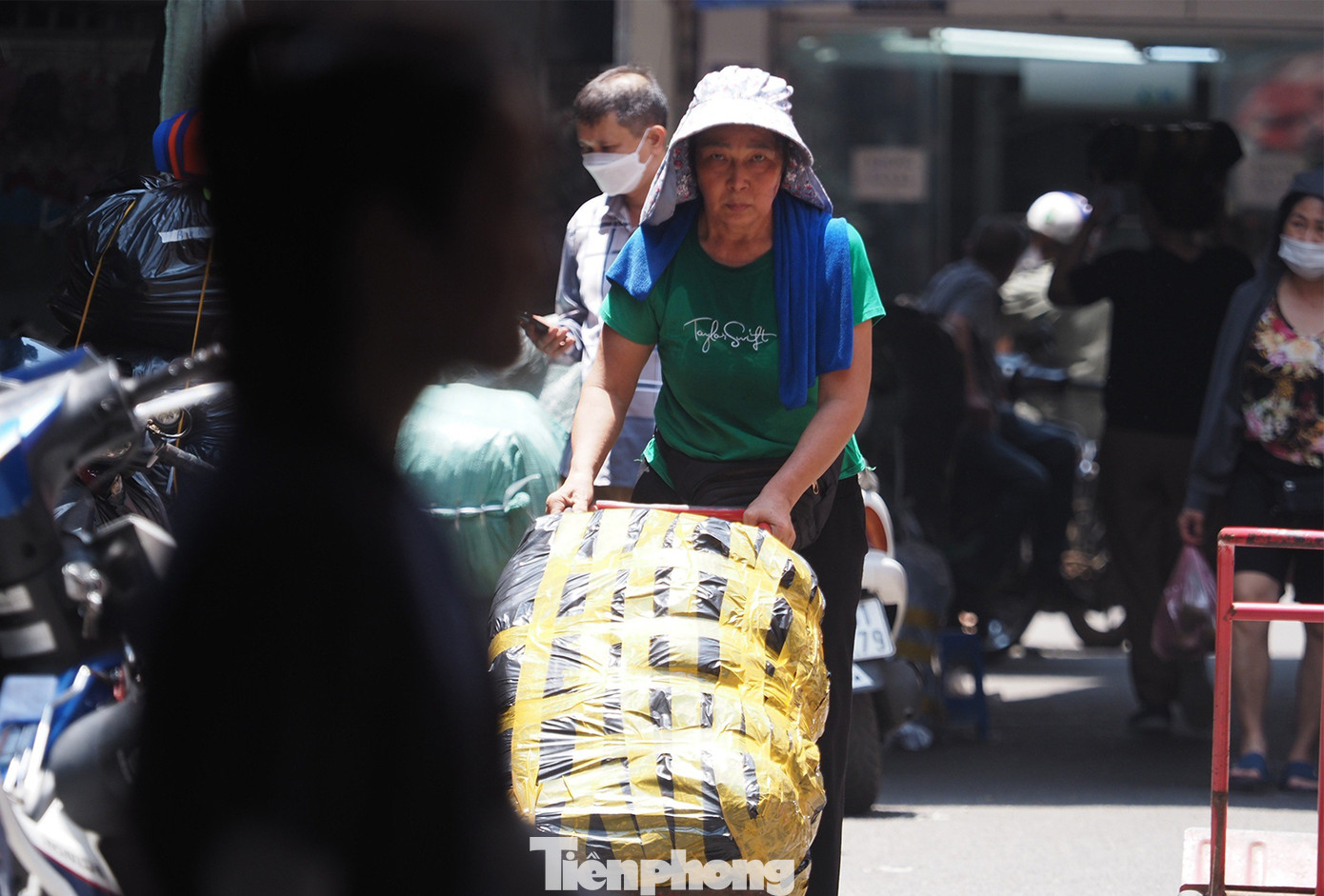 Người lao động bươn chải dưới cái nắng như thiêu như đốt tại chợ Đồng Xuân vào trưa nay.