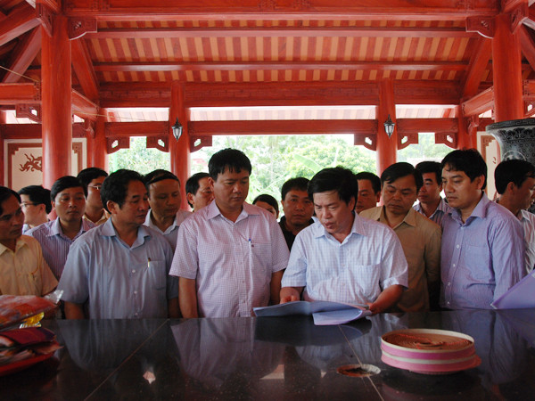 Bộ trưởng Đinh La Thăng và Bí thư thứ nhất Nguyễn Đắc Vinh nghe báo cáo về dự án Khu di tích lịch sử Truông Bồn bên ngôi mộ tập thể TNXP Truông Bồn.