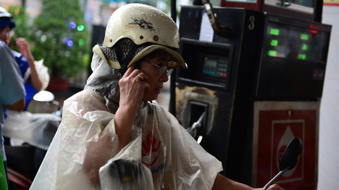 Người dân sử dụng điện thoại ở cây xăng tại vòng xoay Lý Thái Tổ và Lê Hồng Phong, Q.10, TP.HCM. Ảnh: Thuận Thắng