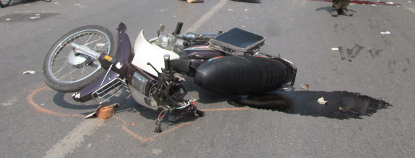 Chiếc xe máy bị nát phần đầu, nằm cách nạn nhân khoảng gần chục mét. Ảnh: Lãng Phong