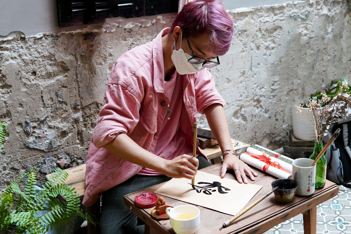 Võ Tuấn Xuân Thành (SN 1999, TPHCM) đã có 15 năm theo đuổi thư pháp. Từ năm 8 tuổi, Thành lần đầu tiên được tiếp cận bộ môn này tại Phố ông đồ ngay Nhà văn hóa thanh niên (quận 1, TPHCM). “Lúc đó mình bắt gặp hình ảnh một người dùng bút lông viết một chữ mà mình đã học trên trường, với hình thức rất lạ là thư pháp. Từ lúc đó mình đã thấy bản thân có duyên với bộ môn này và bắt đầu theo đuổi tới giờ”, Xuân Thành nhớ lại. Trong 15 năm theo đuổi thư pháp, cậu bạn từng được tham gia triển lãm thư pháp ở Văn Miếu Quốc Tử Giám năm 2019. Để nhập môn thư pháp, Xuân Thành chia sẻ: “Giống như việc mình học ở trường vậy, từ nhỏ đã học nét sổ, nét ngang, chữ a, b, c. Thì khi mình học thư pháp, ban đầu mình cũng như đứa trẻ lớp 1, phải học từ những chữ cái rất đơn giản sau đó mới ghép lại thành một câu và thành một bài thơ hoàn chỉnh." Xuân Thành hiện mở lớp dạy viết thư pháp cho mọi lứa tuổi ở TPHCM. Thành mong rằng trong tương lai sẽ có trường học hoặc trung tâm đào tạo chính quy cho bộ môn nghệ thuật này để thư pháp được đến gần hơn với giới trẻ và phát triển rộng rãi, được nhiều người tiếp cận hơn. Cũng như Xuân Thành, Võ Thị Kiều Trâm (SN 1998, TPHCM) bén duyên với thư pháp Việt Nam từ khi là nữ sinh cấp 2. Đến nay, cô bạn đã theo đuổi bộ môn nghệ thuật này được gần 7 năm. Trâm chia sẻ: “Trước đó mình theo đuổi vì cảm thấy thích, thấy lạ, lâu dần mình quen với các con chữ và ngày càng cảm thấy thích thú. Từ đó mình tự mày mò học hỏi tới khi học đại học mới quyết định lên TPHCM để trau dồi thêm kinh nghiệm. Sau đó mình bén duyên với phố ông đồ ở Nhà văn hóa thanh niên, và tham gia đến hiện tại”. "Thư pháp với mình là niềm đam mê rất lớn, giống như đứa con tinh thần, mình không bỏ được. Khi làm việc mệt mỏi mình về nhìn những con chữ, xoay quanh bút, mực khiến cuộc sống mình thay đổi rất nhiều. Mình thay đổi từ tính cách, đến thay đổi những lối sống hằng ngày, giúp mình rèn luyện sự tỉ mẩn khi viết từng con chữ." Kiều Trâm bày tỏ. Hiện Kiều Trâm đang sở hữu một trang bán thư pháp online. Trâm thường nhận viết bao lì xì là chủ yếu, mỗi chiếc có giá 10.000 đồng. Cô chia sẻ, sắp tới sẽ mở một triển lãm nhỏ về thư pháp để kỷ niệm 10 năm theo đuổi bộ môn này. Bằng sự nhiệt huyết của tuổi trẻ, cô mong có thể giữ gìn và phát triển nền thư pháp Việt Nam đến rộng rãi mọi người, không kén chọn độ tuổi.