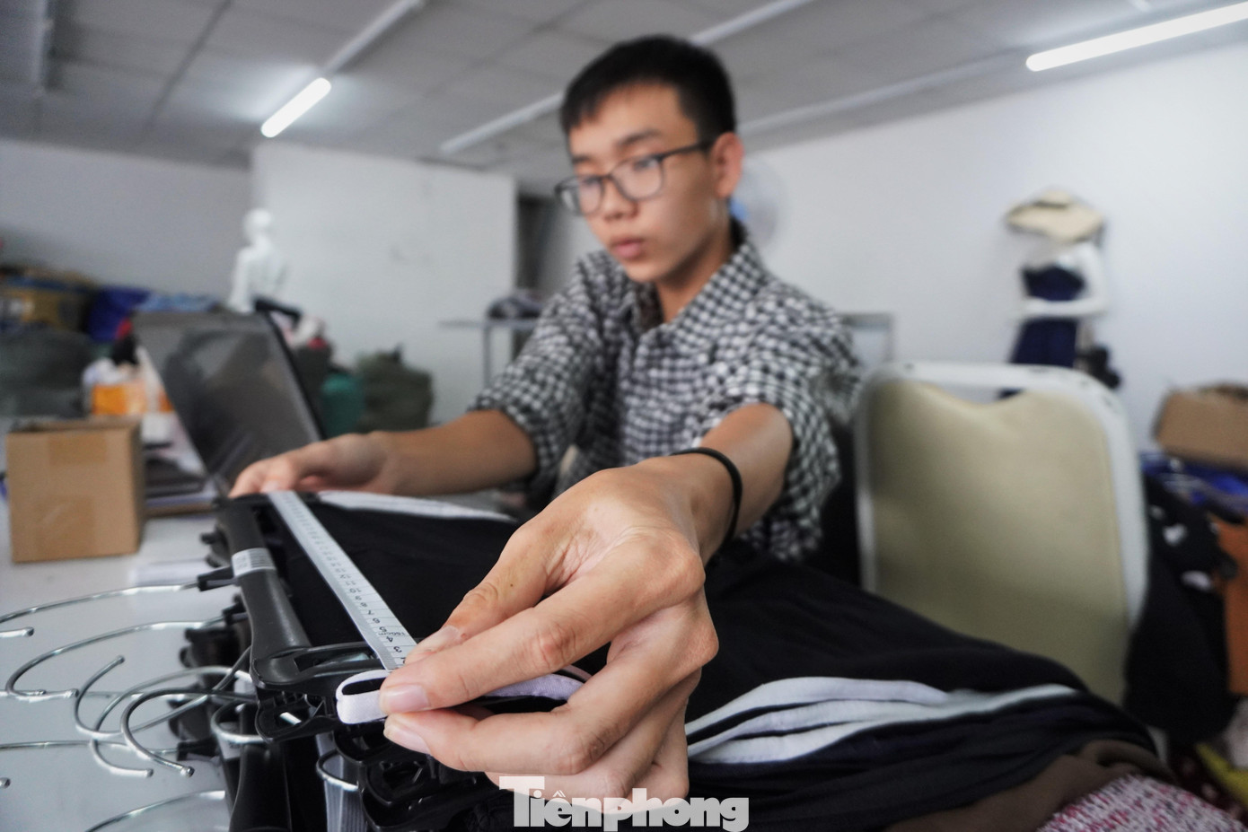 Quần áo cũ được đo kích cỡ để phân loại size, dán mã code trước khi đăng tải lên trang bán hàng trực tuyến.