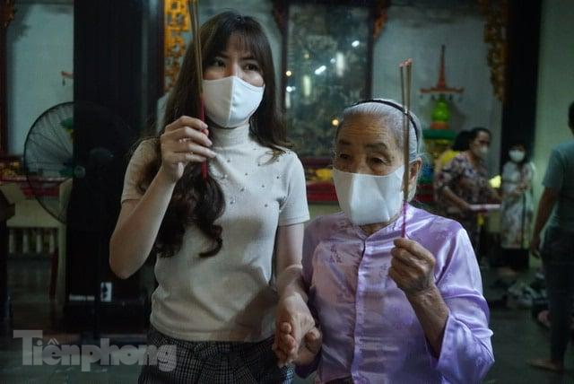 Hai bà cháu đến chùa sau thời khắc giao thừa với mong muốn đi lấy lộc đầu năm và cầu mong một năm mới bình an, khỏe mạnh. Bà Tư (bên phải) chia sẻ: "May mắn thay là năm vừa qua tôi chưa bị COVID, giờ đến đây chỉ cầu sức khỏe." Hai bà cháu đến chùa sau thời khắc giao thừa với mong muốn đi lấy lộc đầu năm và cầu mong một năm mới bình an, khỏe mạnh. Bà Tư (bên phải) chia sẻ: "May mắn thay là năm vừa qua tôi chưa bị COVID, giờ đến đây chỉ cầu sức khỏe."