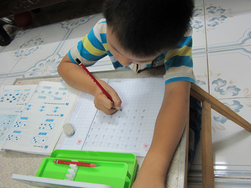 Ở nhà, Hiếu tự giác mang vở ra tập viết