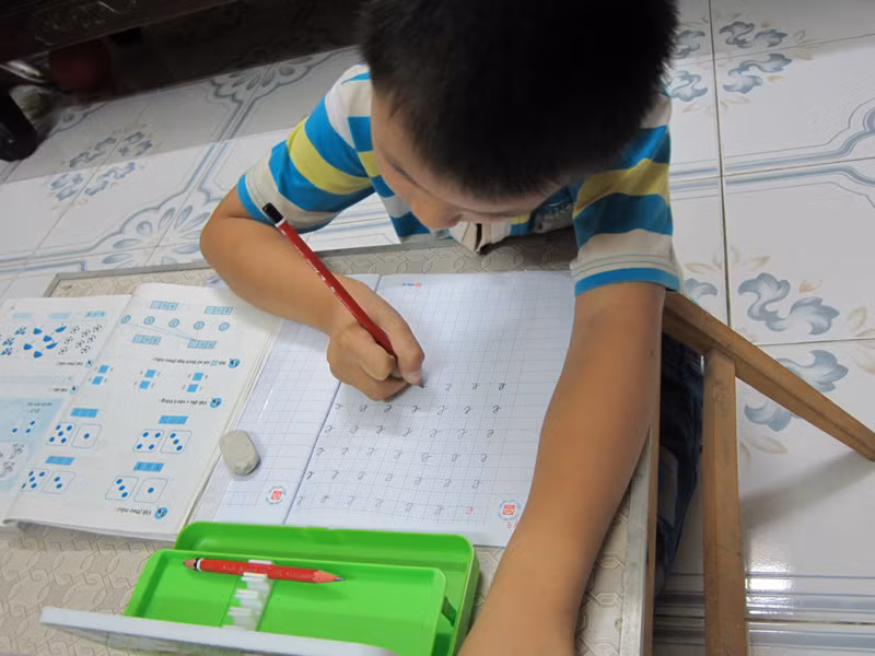 Ở nhà, Hiếu tự giác mang vở ra tập viết