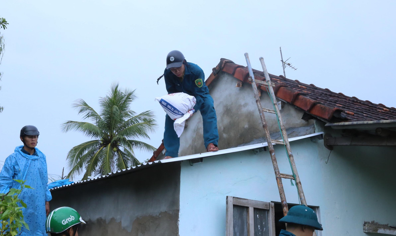 Tại xã Tam Thanh (TP. Tam Kỳ), lực lượng bộ đội, dân quân, công an xã… đang hỗ trợ người dân chằng chống lại nhà cửa. Các bao cát, nước được đưa lên kè các mái nhà tôn phòng gió bão tốc đi.