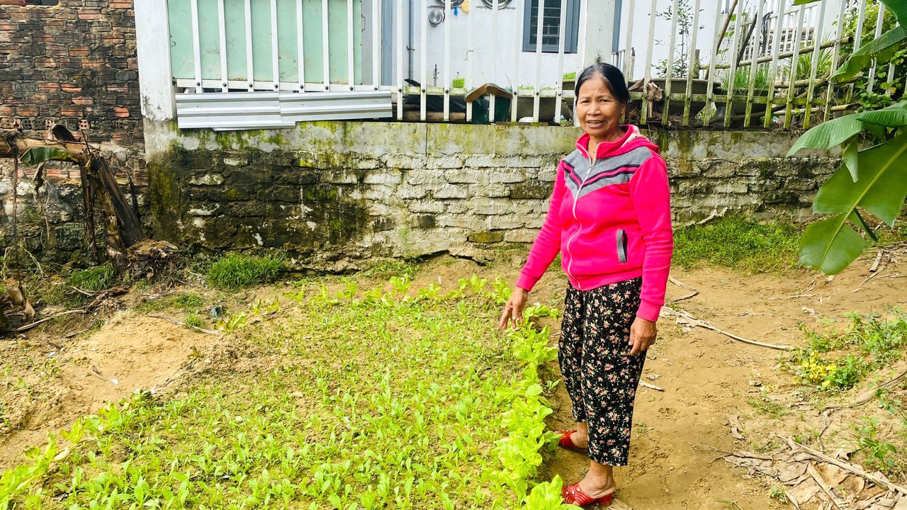 Bà Hứa Thị Dân (áo đỏ) nhận được 4 triệu đồng tiền bồi thường thiệt hại sau sự cố máy bay rơi.