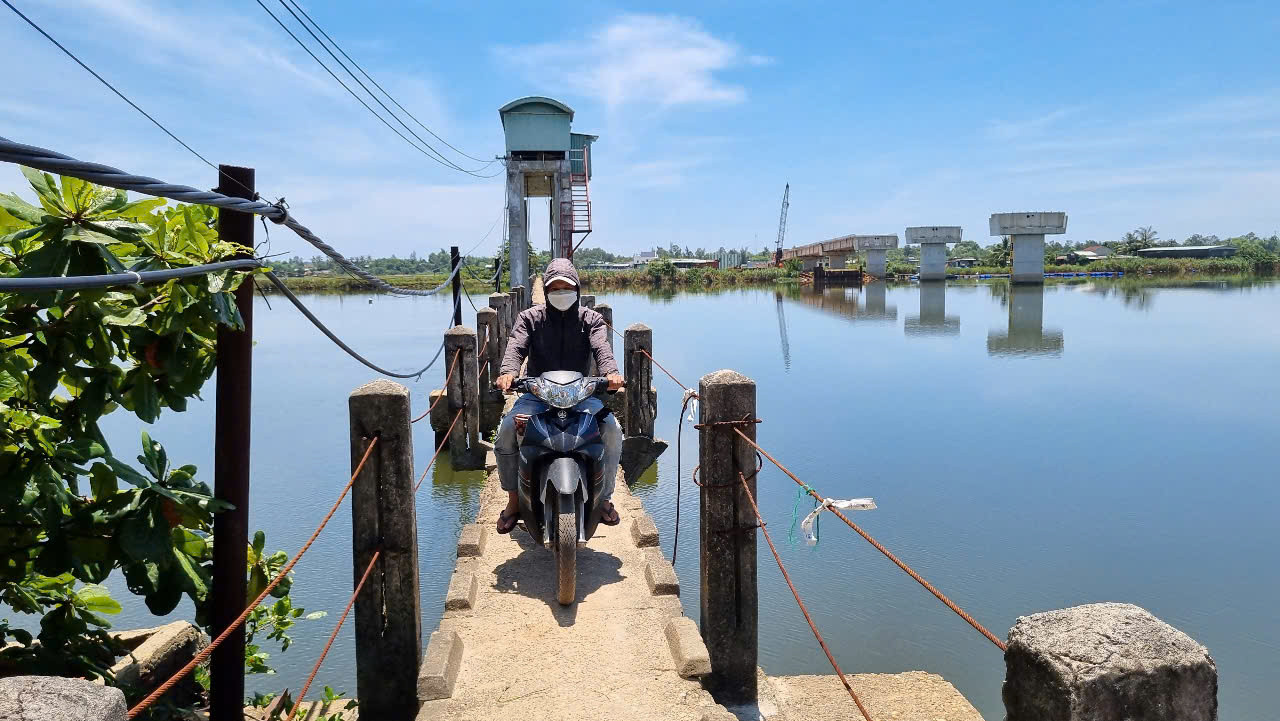 Trong khi đó, người dân 2 xã mòn mỏi trông đợi, bởi cầu xây chưa xong thì họ phải đi vòng xa hơn 10 cây số hoặc đi qua cây cầu máng đã cũ, còn gọi là cầu vĩnh biệt.