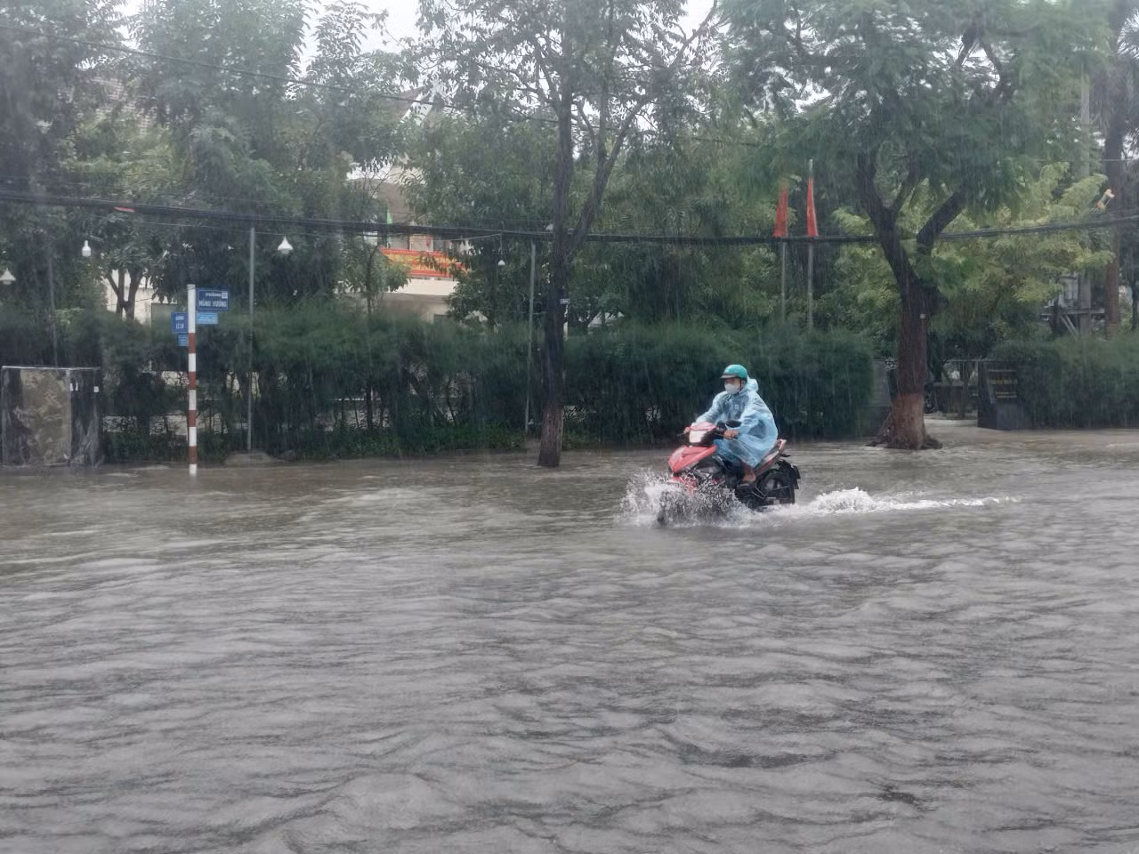 Người dân chật vật di chuyển khi phố biến thành sông. Người dân chật vật di chuyển khi phố biến thành sông.