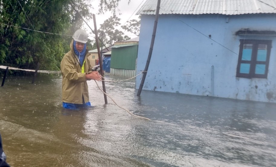 Người dân căng dây để di chuyển giữa vùng ngập sâu.