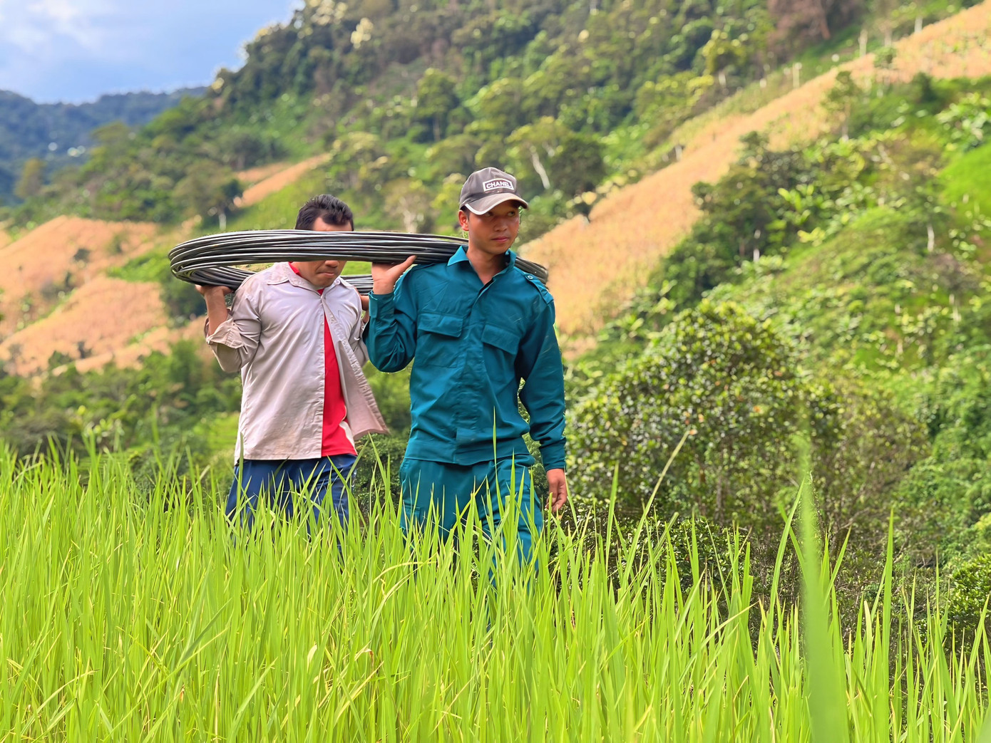 Mỗi người kề vai khiêng, cõng vật liệu vào điểm xây cầu. Các lực lượng tại chỗ và người dân cũng đã có mặt, xắn tay hỗ trợ.