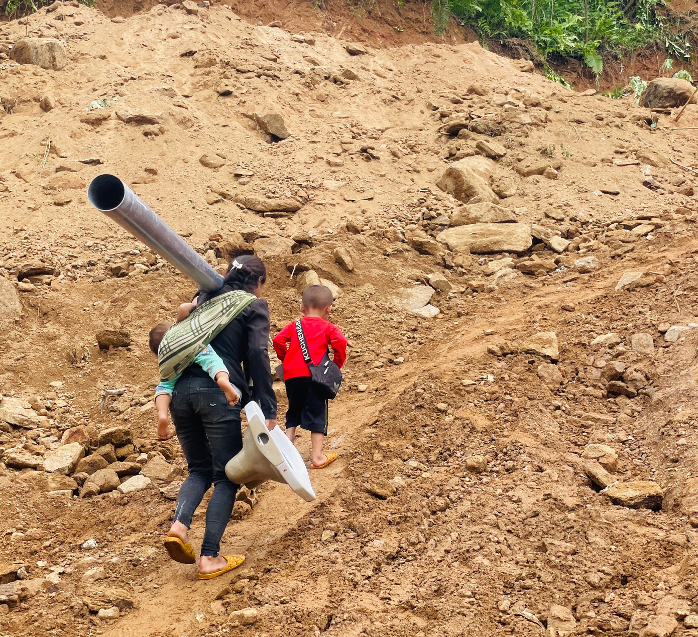 Mọi người cùng nhau lội bộ vận chuyển vật liệu về làng.