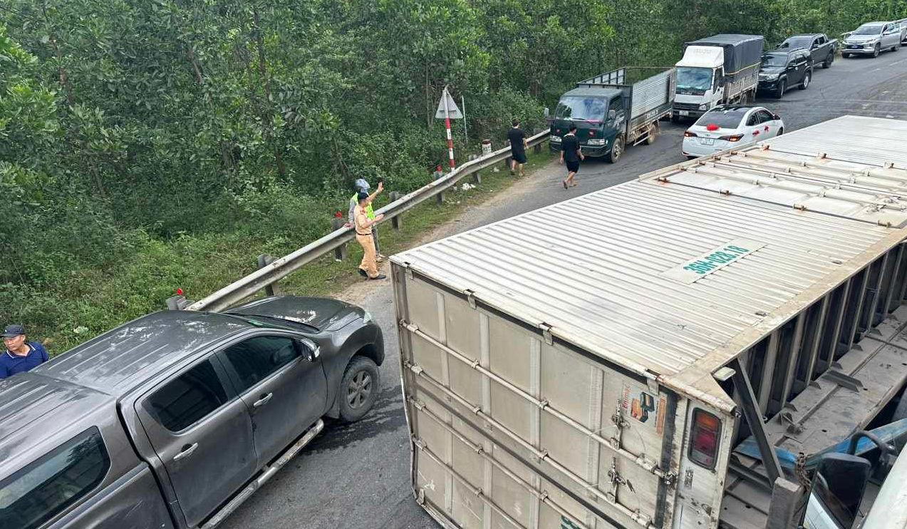 Chiếc xe tải lật nằm ngang đường khiến giao thông ách tắc.