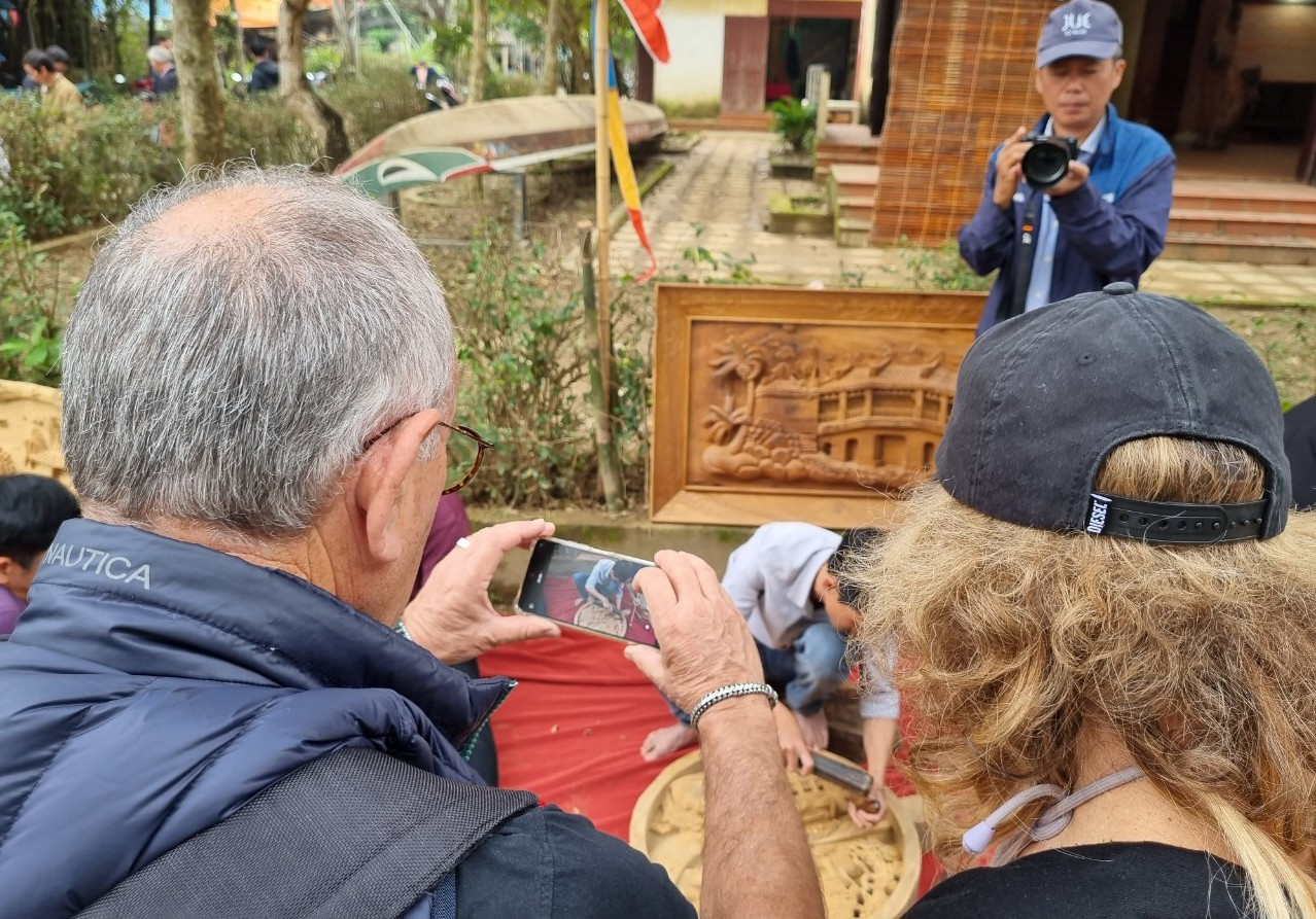 Du khách ghi lại những khoảnh khắc trải nghiệm tại làng nghề.