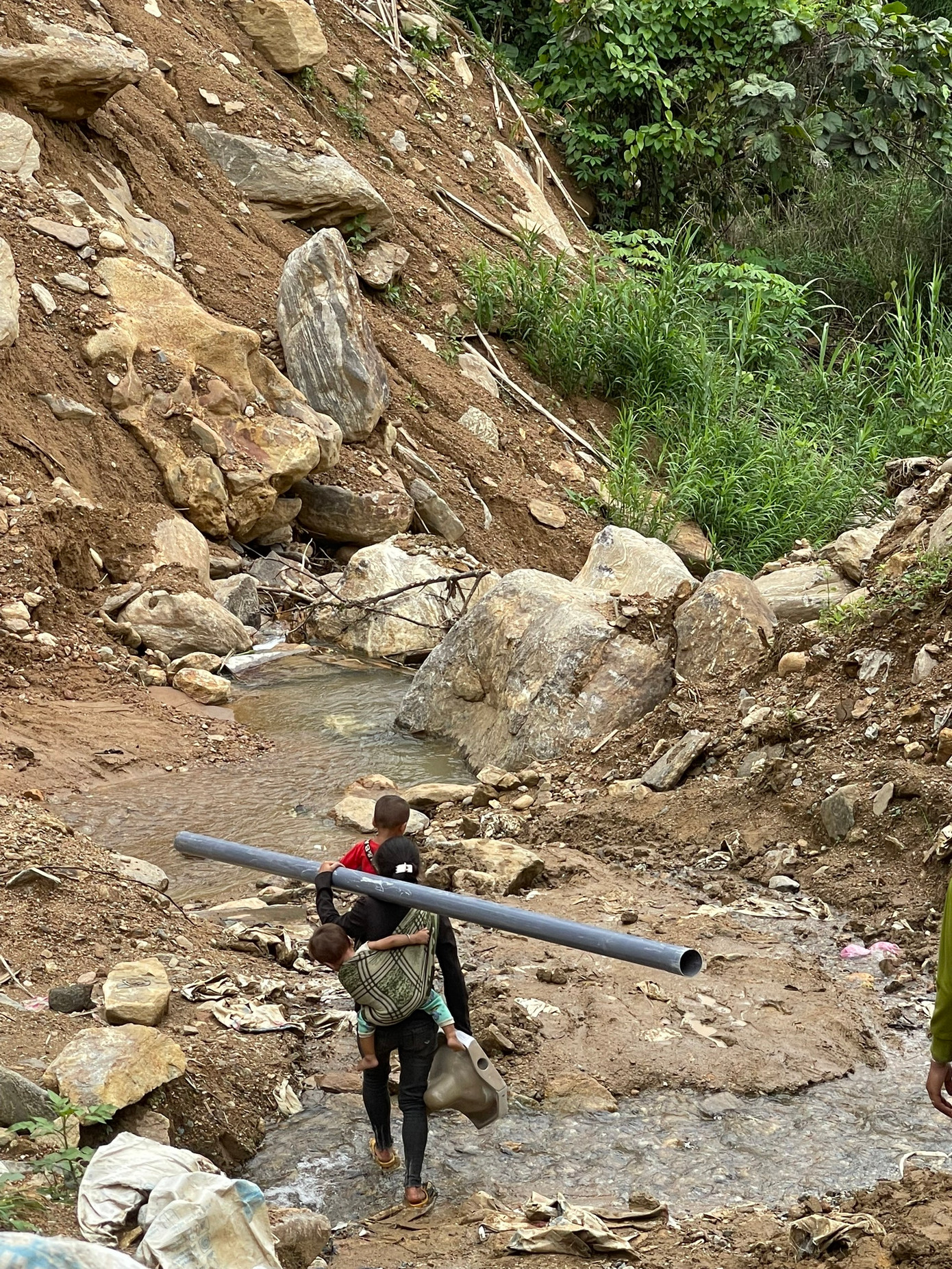 Mẹ con cùng vận chuyển vật liệu về làng