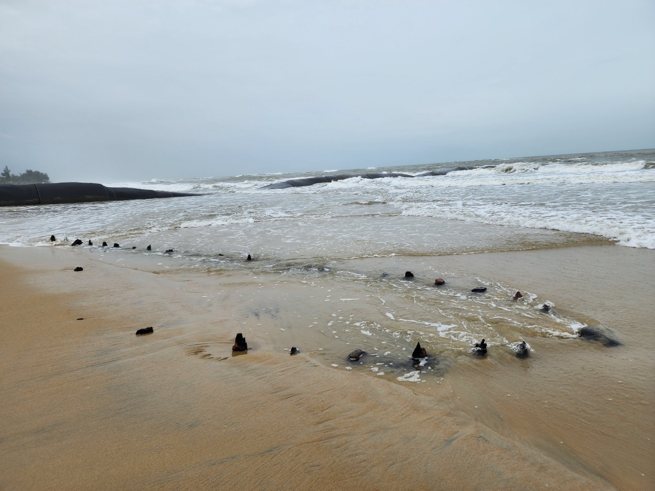 Hình ảnh xác con tàu nghi tàu cổ trồi lên gần bờ biển phường Cẩm An được ghi lại trước đó.