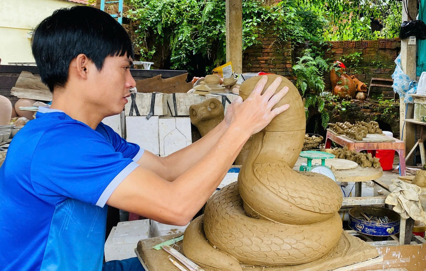 Thợ trẻ Lê Văn Nhật đang dày công tạo hình cặp linh vật rắn. Thợ trẻ Lê Văn Nhật đang dày công tạo hình cặp linh vật rắn.