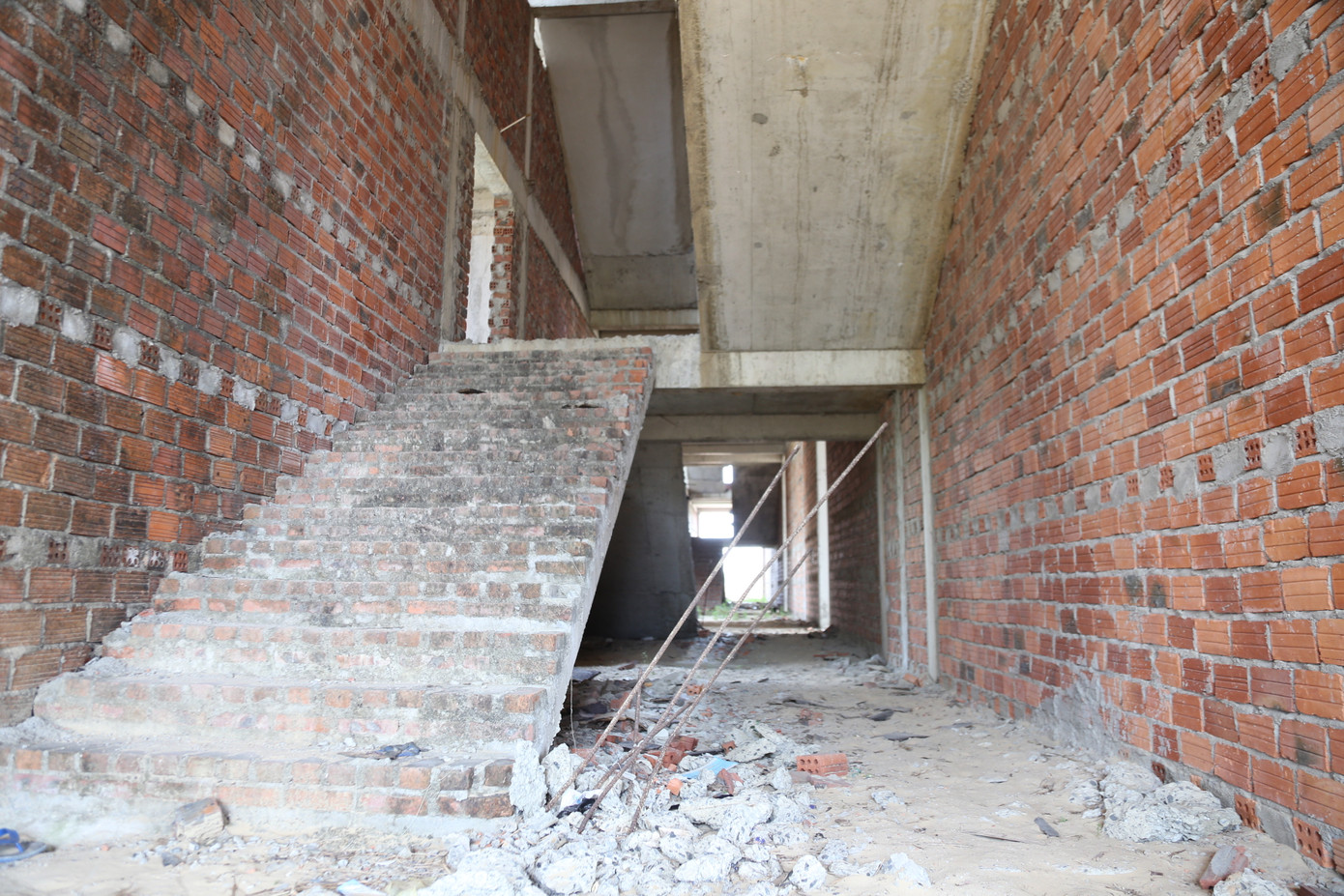 Ba tòa nhà xây dựng dang dở, bên trong nhiều hạng mục để lâu hư hỏng, hoen gỉ, rêu mốc, cây cỏ mọc um tùm.