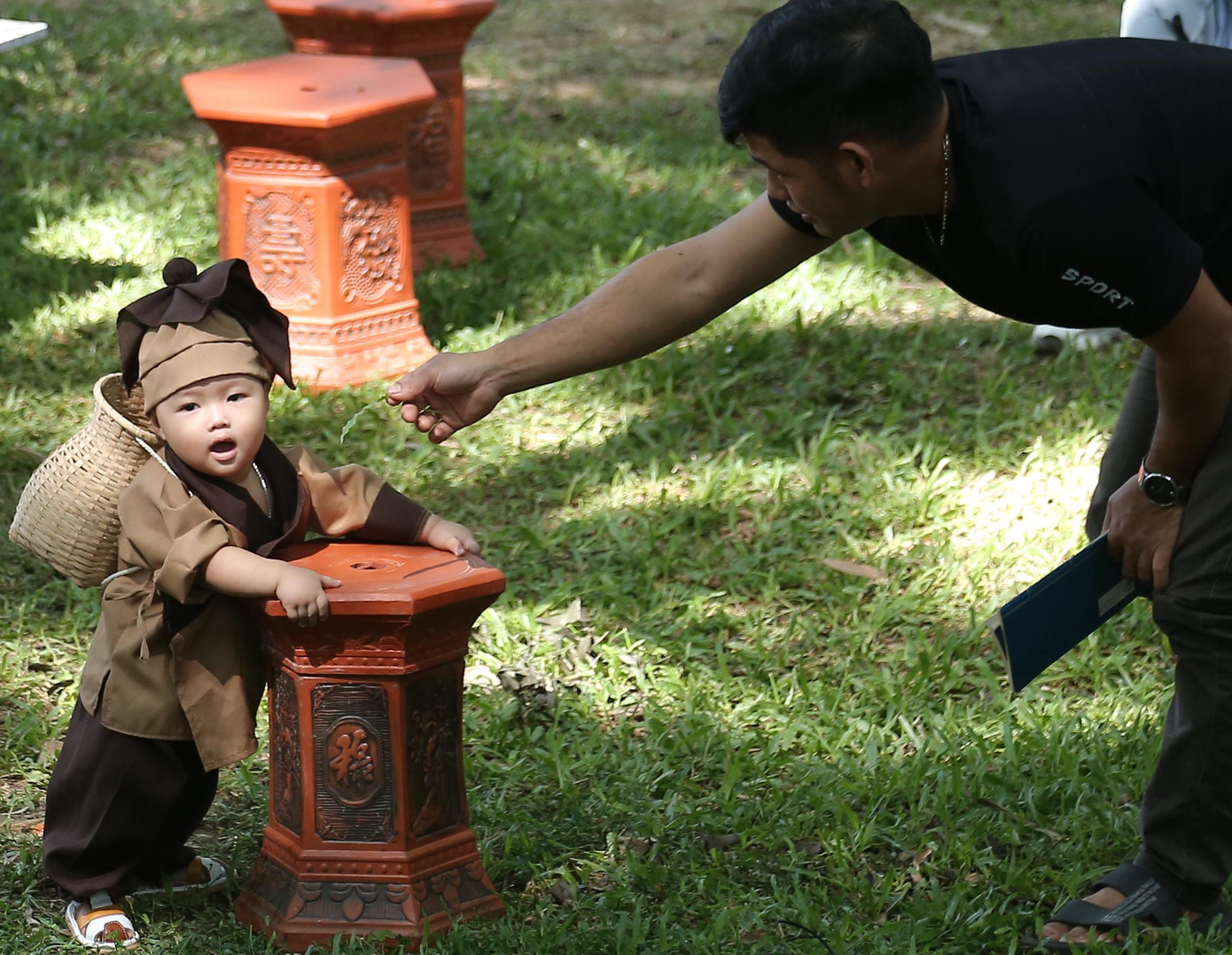 Một cậu bé được bố mẹ diện đồ nông dân chụp hình kỷ niệm tại ngày hội.