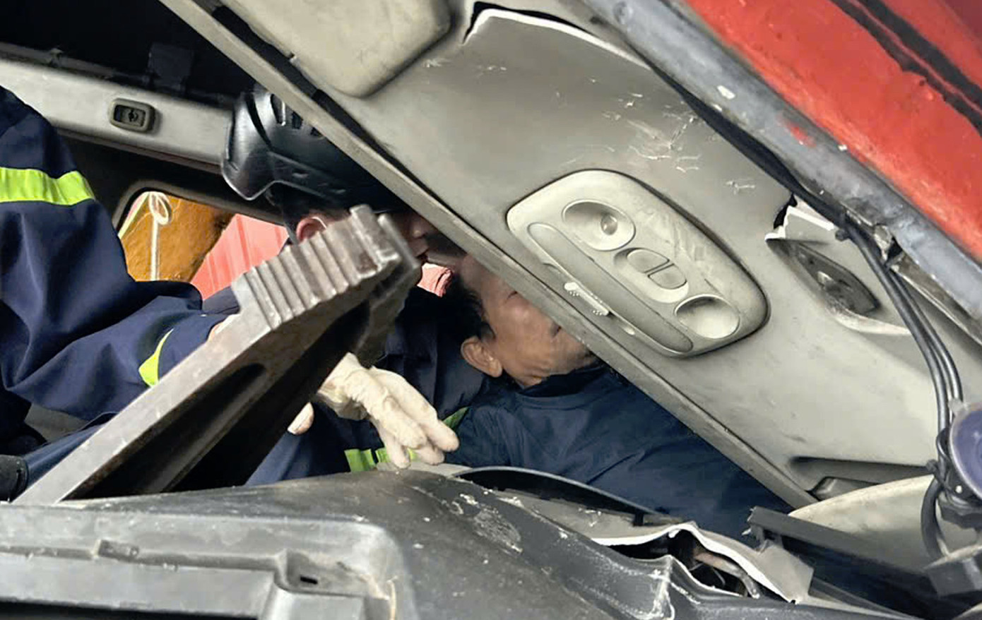 Lực lượng chức năng tỉnh Quảng Nam kịp thời có mặt tại hiện trường giải cứu tài xế xe đầu kéo gặp nạn. Ảnh CA