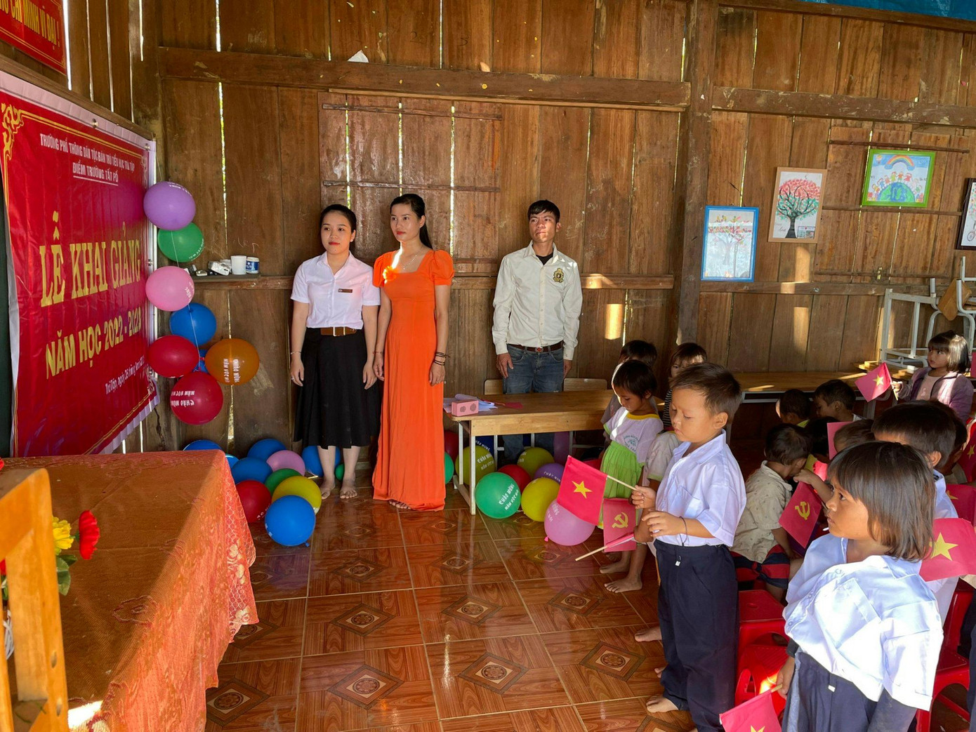 Lớp học được trang trí những chùm bóng bay, bục giảng treo trang trọng lá cờ đỏ sao vàng, chiếc bàn nhỏ đặt ảnh Bác Hồ. Các em học sinh đồng bào Ca Dong tay cầm lá cờ nhỏ cùng chào cờ, hát quốc ca. Lớp học được trang trí những chùm bóng bay, bục giảng treo trang trọng lá cờ đỏ sao vàng, chiếc bàn nhỏ đặt ảnh Bác Hồ. Các em học sinh đồng bào Ca Dong tay cầm lá cờ nhỏ cùng chào cờ, hát quốc ca.