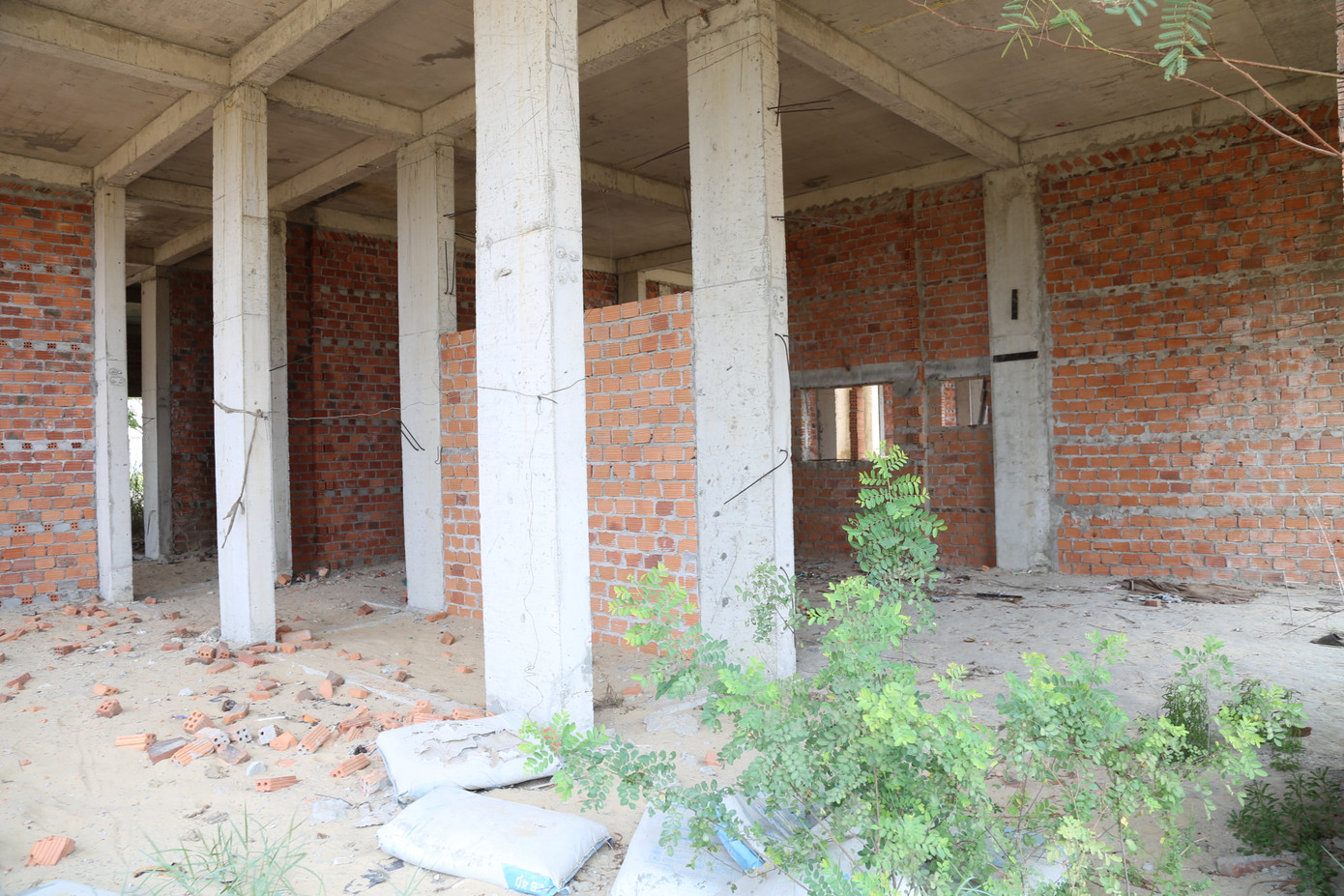 Ba tòa nhà xây dựng dang dở, bên trong nhiều hạng mục để lâu hư hỏng, hoen gỉ, rêu mốc, cây cỏ mọc um tùm.