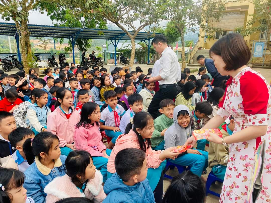 Trao lì xì cho học sinh buổi chào cờ đầu tiên năm mới.