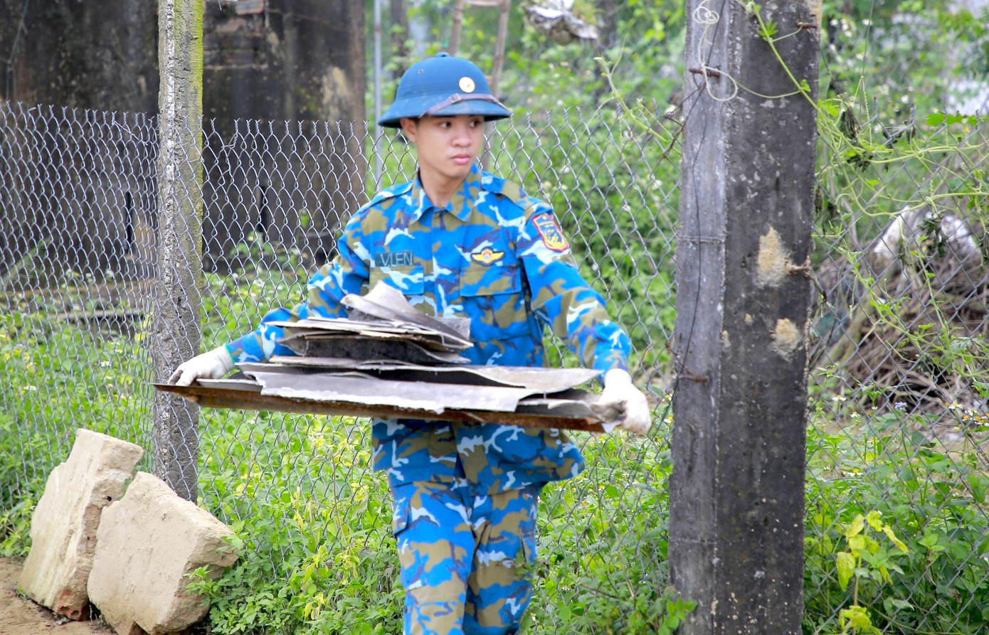 Các chiến sĩ dỡ mảnh tôn bị vỡ, lợp lại mới cho người dân.