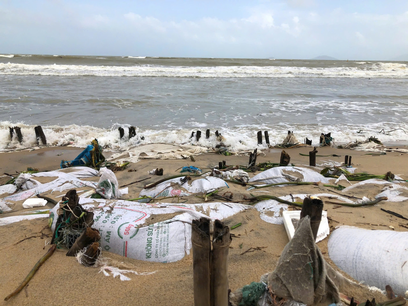 Bờ kè tạm bị sóng biển dâng cao kèm theo gió mạnh đã làm hư hỏng, cuốn trôi một khối lượng lớn cát.