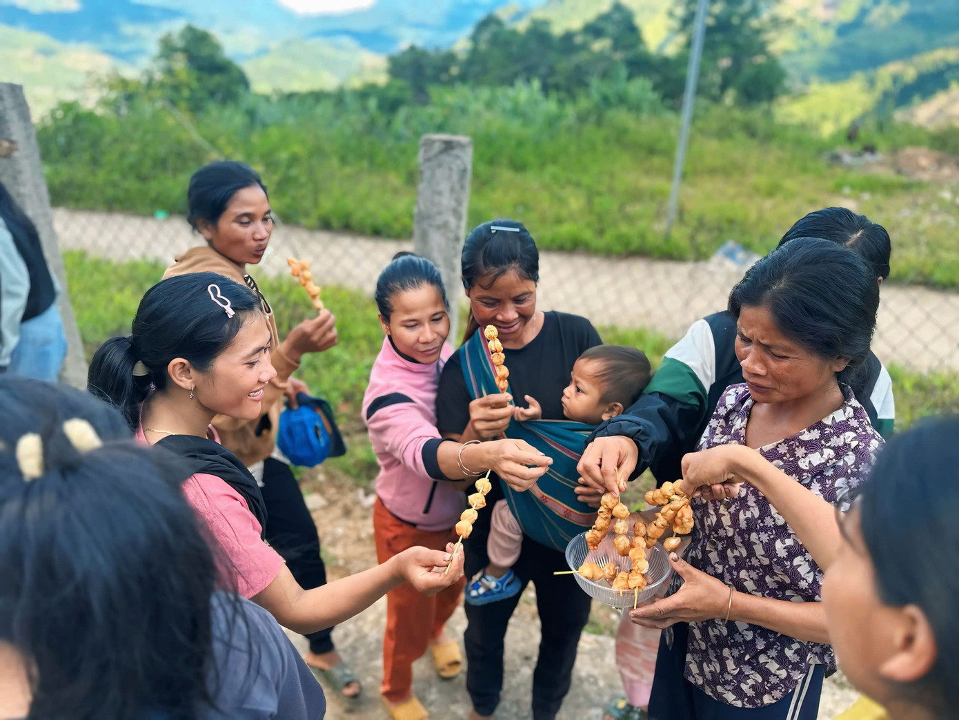 Các tình nguyện viên mời từng em nhỏ, bà con trong làng thưởng thức.