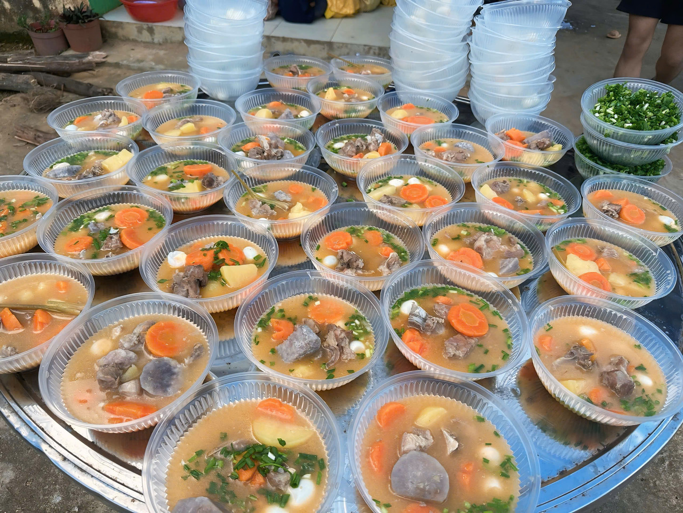 Không chỉ tặng quà, các tình nguyện viên còn chuẩn bị bữa ăn với hàng xâu cá viên chiên, hàng chục tô xương hầm rau củ quả gửi đến người dân trong làng.