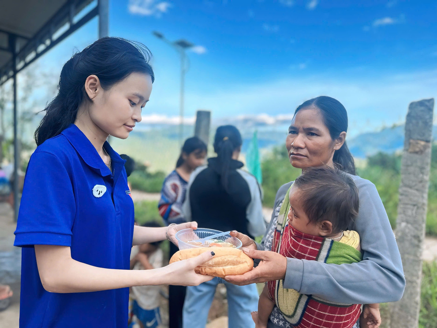 Các tình nguyện viên mời từng em nhỏ, bà con trong làng thưởng thức.